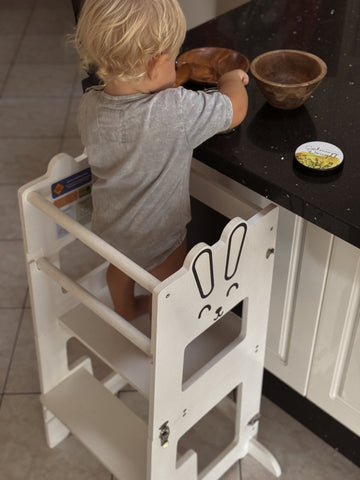 A Child standing on a Learning Tower