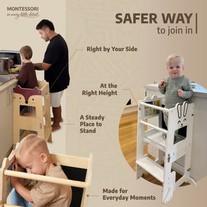 Toddler standing safely in the bunny and fox learning towers at the kitchen counter with a parent