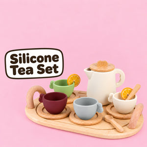 Silicone Tea Set on a wooden tray with teapot, four cups, saucers, spoons and lemon slices