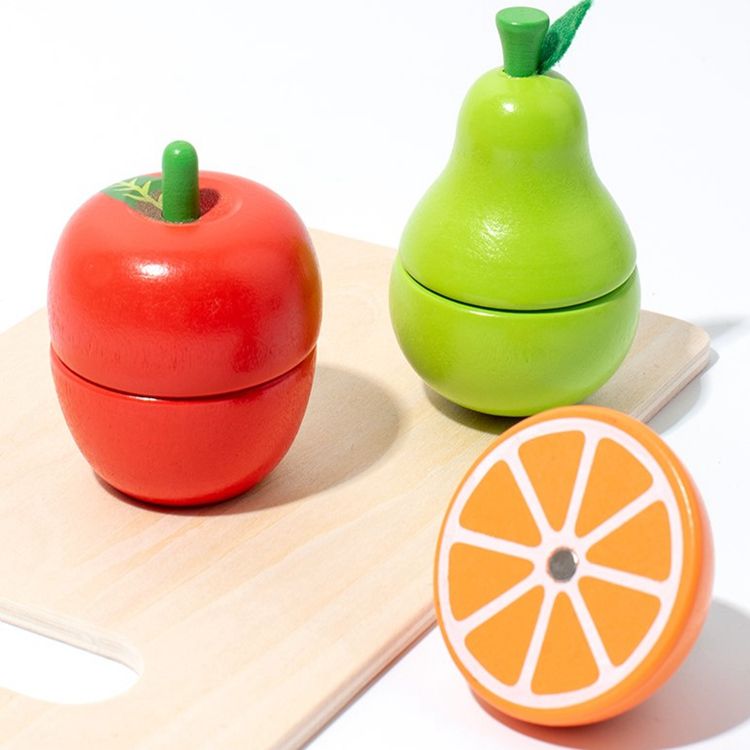 Wooden play apple, pear and orange on a chopping board